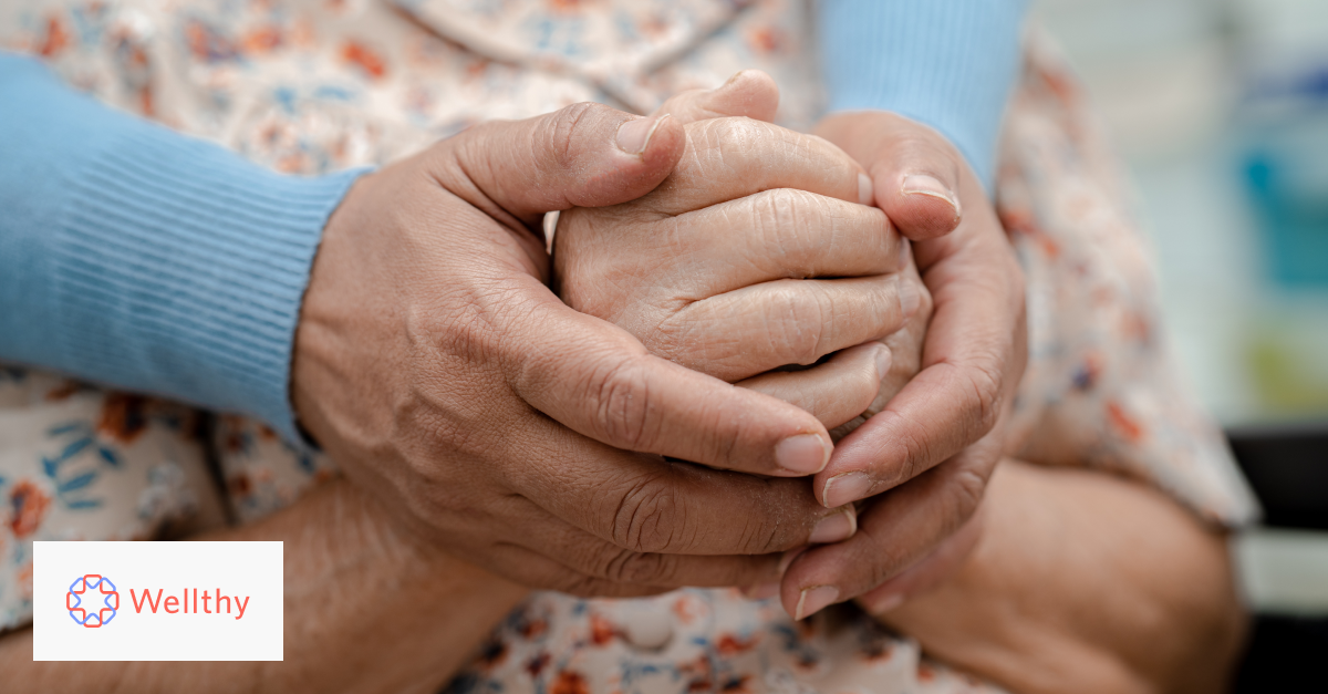 A close-up photo of someone lovingly holding an elderly woman's hands.