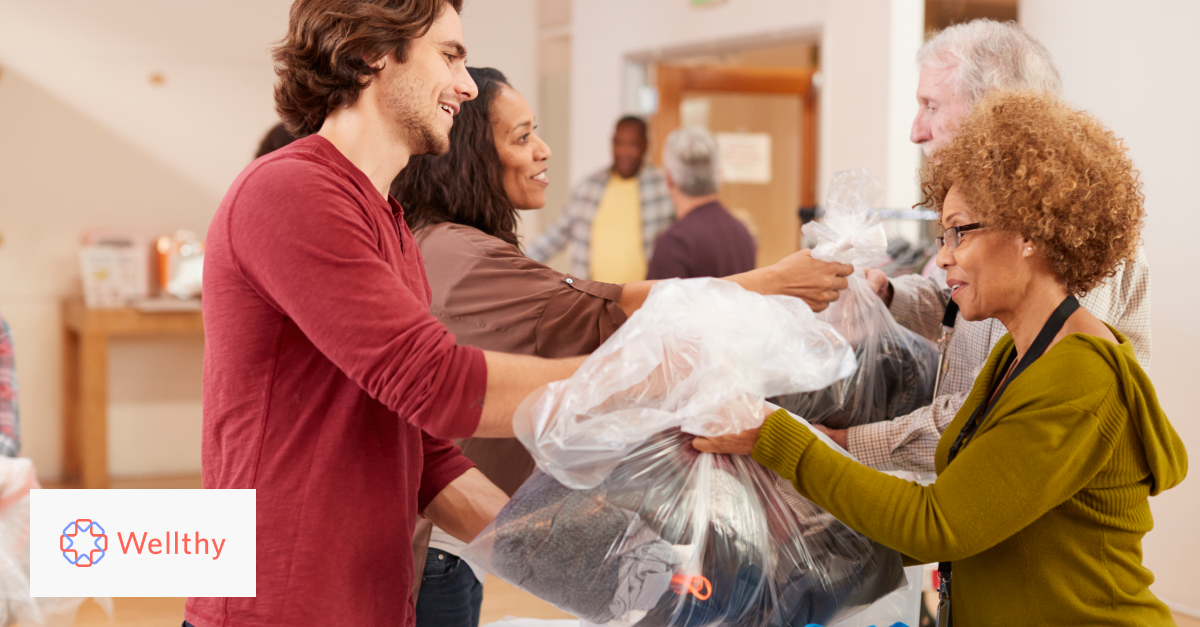 A man in a red shirt donating clothing to charity collection in community center